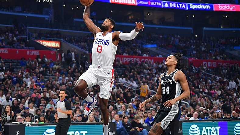 Oct 29, 2023; Los Angeles, California, USA; Los Angeles Clippers forward Paul George (13) scores a basket ahead of San Antonio Spurs guard Devin Vassell (24) during the first half at Crypto.com Arena. Mandatory Credit: Gary A. Vasquez-USA TODAY Sports