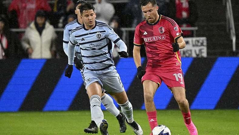 Oct 29, 2023; St. Louis, MO, USA; St. Louis City midfielder Indiana Vassilev (19) dribbles against Sporting Kansas City midfielder Nemanja Radoja (6) in the first half of game one in a round one match of the 2023 MLS Cup Playoffs at CITYPARK. Mandatory Credit: Scott Rovak-USA TODAY Sports