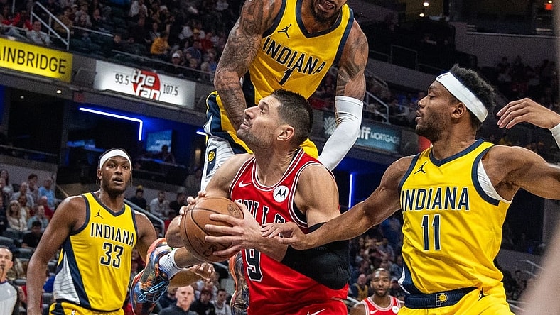 Oct 30, 2023; Indianapolis, Indiana, USA; Chicago Bulls center Nikola Vucevic (9) shoots the ball while Indiana Pacers forward Obi Toppin (1) and forward Bruce Brown (11) defend in the first quarter at Gainbridge Fieldhouse. Mandatory Credit: Trevor Ruszkowski-USA TODAY Sports