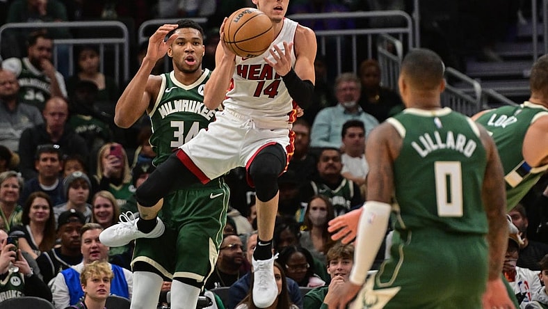 Oct 30, 2023; Milwaukee, Wisconsin, USA;  Miami Heat guard Tyler Herro (14) grabs a rebound against Milwaukee Bucks forward Giannis Antetokounmpo (34) in the first quarter at Fiserv Forum. Mandatory Credit: Benny Sieu-USA TODAY Sports