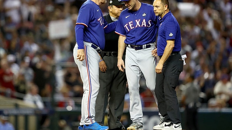 Oct 30, 2023; Phoenix, AZ, USA; Texas Rangers pitcher Max Scherzer (31) talks to manager Bruce Bochy (15) and a trainer before leaving the game in the fourth inning in game three of the 2023 World Series against the Arizona Diamondbacks at Chase Field. Mandatory Credit: Mark J. Rebilas-USA TODAY Sports