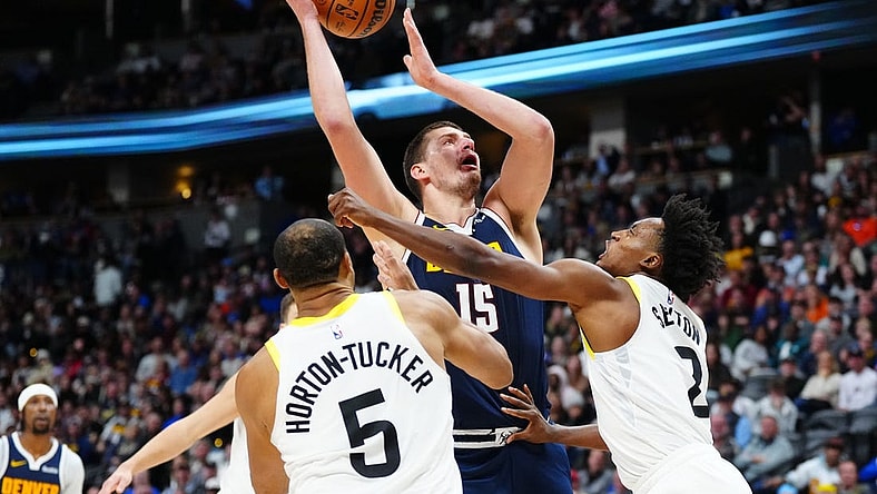 Oct 30, 2023; Denver, Colorado, USA; Utah Jazz guard Collin Sexton (2) fouls Denver Nuggets center Nikola Jokic (15) in the second half at Ball Arena. Mandatory Credit: Ron Chenoy-USA TODAY Sports