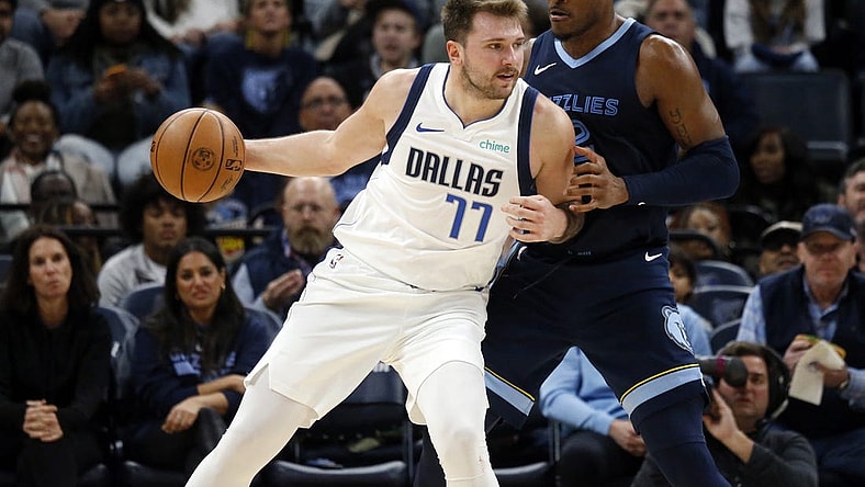 Oct 30, 2023; Memphis, Tennessee, USA; Dallas Mavericks guard Luka Doncic (77) handles the ball as Memphis Grizzlies forward Xavier Tillman (2) defends during the second half at FedExForum. Mandatory Credit: Petre Thomas-USA TODAY Sports