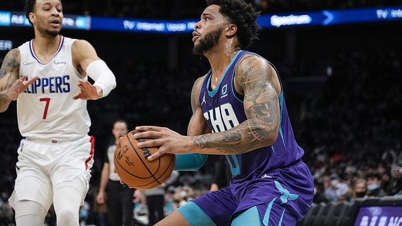 Jan 30, 2022; Charlotte, North Carolina, USA; Charlotte Hornets forward Miles Bridges (0) pulls up for a jumper defended by LA Clippers guard Amir Coffey (7) during the second quarter at the Spectrum Center. Mandatory Credit: Jim Dedmon-USA TODAY Sports