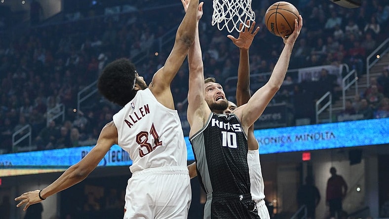 Dec 9, 2022; Cleveland, Ohio, USA; Sacramento Kings forward Domantas Sabonis (10) drives to the basket against Cleveland Cavaliers center Jarrett Allen (31) and forward Evan Mobley (4) during the first half at Rocket Mortgage FieldHouse. Mandatory Credit: Ken Blaze-USA TODAY Sports
