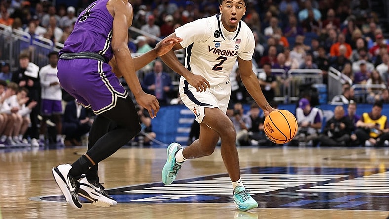 Mar 16, 2023; Orlando, FL, USA; Virginia Cavaliers guard Reece Beekman (2) dribbles the ball while defended by Furman Paladins guard Marcus Foster (5) during the second half at Amway Center. Mandatory Credit: Matt Pendleton-USA TODAY Sports