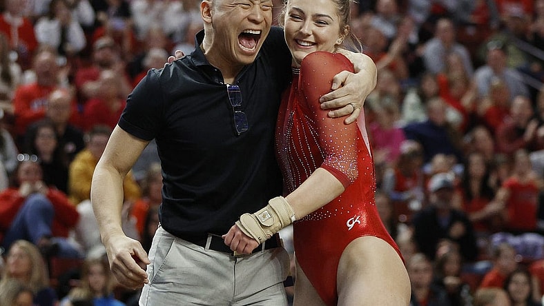 Mar 18, 2023; West Valley City, UT, USA; Utah s head gymnastics coach Tom Farden celebrates with Lucy Stanhope after her vault during the Pac-12 Women's Gymnastics Championship at Maverik Center. Mandatory Credit: Jeffrey Swinger-USA TODAY Sports