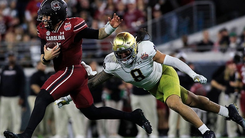 Notre Dame Fighting Irish linebacker Marist Liufau (8) tries to sack the South Carolina Quarterback Spencer Rattler (7). The University of Notre Dame Fighting Irish took on the University of South Carolina Gamecocks in the TaxSlayer Gator Bowl game in Jacksonville, Florida's TIAA Bank Field Friday, December 30, 2022. The first half ended with South Carolina holding a 24 to 17 lead.