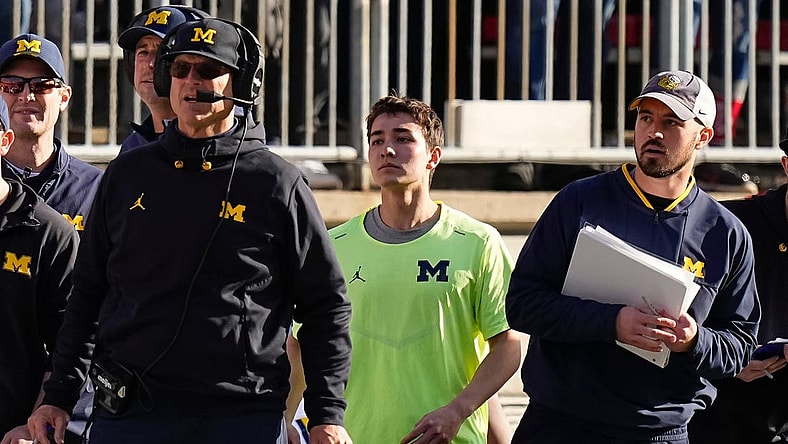 Nov 26, 2022; Columbus, Ohio, USA; Michigan Wolverines head coach Jim Harbaugh watches from the sideline beside off-field analyst Connor Stalions, right, during the NCAA football game against the Ohio State Buckeyes at Ohio Stadium.