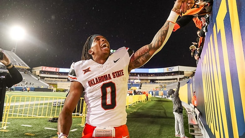 Oct 21, 2023; Morgantown, West Virginia, USA; Oklahoma State Cowboys running back Ollie Gordon II (0) celebrates with fans after defeating the West Virginia Mountaineers at Mountaineer Field at Milan Puskar Stadium. Mandatory Credit: Ben Queen-USA TODAY Sports