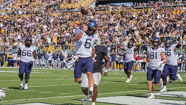 Oct 28, 2023; Orlando, Florida, USA; West Virginia Mountaineers quarterback Garrett Greene (6) scores a touchdown against the UCF Knights during the second half at FBC Mortgage Stadium. Mandatory Credit: Mike Watters-USA TODAY Sports
