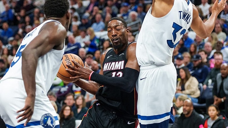 Oct 28, 2023; Minneapolis, Minnesota, USA; Miami Heat center Bam Adebayo (13) drives to the basket as Minnesota Timberwolves center Karl-Anthony Towns (32) and guard Anthony Edwards (5) defend in the second quarter at Target Center. Mandatory Credit: Matt Blewett-USA TODAY Sports