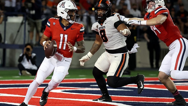 Oct 28, 2023; Tucson, Arizona, USA; Arizona Wildcats quarterback Noah Fifita #11 drops back to make a pass against Oregon State Beavers defensive lineman Sione Lolohea #8 during the first half at Arizona Stadium. Mandatory Credit: Zachary BonDurant-USA TODAY Sports