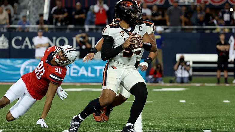 Oct 28, 2023; Tucson, Arizona, USA; Oregon State Beavers quarterback DJ Uiagalelei #5 makes a pass against Arizona Wildcats defensive lineman Isaiah Ward #90 during the second half at Arizona Stadium. Mandatory Credit: Zachary BonDurant-USA TODAY Sports