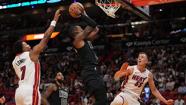 Nov 1, 2023; Miami, Florida, USA; Brooklyn Nets guard Lonnie Walker IV (8) puts up a shot between Miami Heat guard Kyle Lowry (7) and forward Duncan Robinson (55) during the first half at Kaseya Center. Mandatory Credit: Jasen Vinlove-USA TODAY Sports