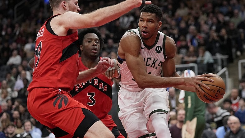 Nov 1, 2023; Toronto, Ontario, CAN; Milwaukee Bucks forward Giannis Antetokounmpo (34) tries to pass the ball against Toronto Raptors center Jakob Poeltl (19) during the second half at Scotiabank Arena. Mandatory Credit: John E. Sokolowski-USA TODAY Sports