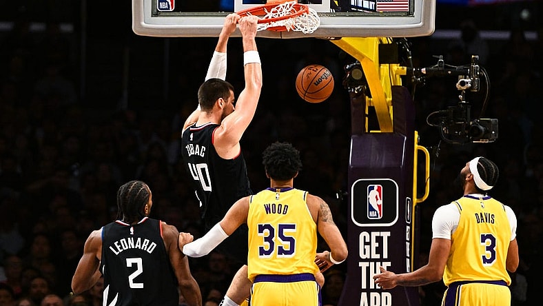 Nov 1, 2023; Los Angeles, California, USA;  LA Clippers center Ivica Zubac (40) dunks the ball against Los Angeles Lakers forward Christian Wood (35) and guard D'Angelo Russell (1) during the first quarter at Crypto.com Arena. Mandatory Credit: Jonathan Hui-USA TODAY Sports