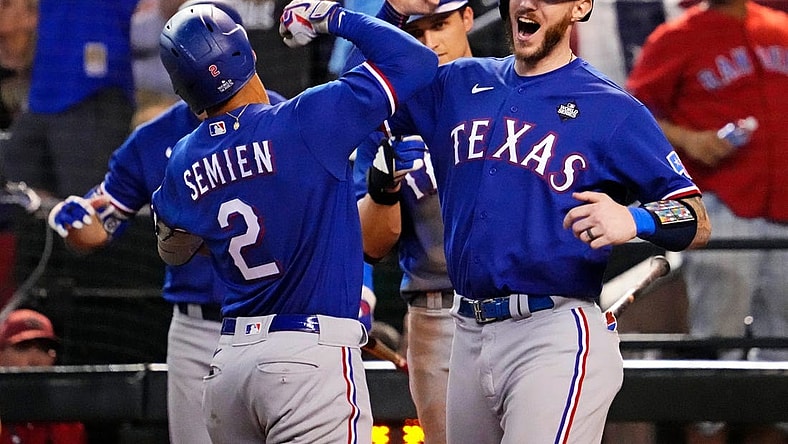 Texas Rangers second baseman Marcus Semien (2) celebrates with shortstop Corey Seager (5) after hitting a two run home run during the ninth inning against the Arizona Diamondbacks during game five of the 2023 World Series at Chase Field.