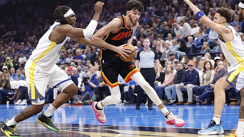 Nov 3, 2023; Oklahoma City, Oklahoma, USA; Oklahoma City Thunder forward Chet Holmgren (7) drives between Golden State Warriors forward Kevon Looney (5) and guard Klay Thompson (11) during the second quarter at Paycom Center. Mandatory Credit: Alonzo Adams-USA TODAY Sports