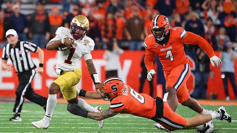 Nov 3, 2023; Syracuse, New York, USA; Boston College Eagles quarterback Thomas Castellanos (1) runs with the ball as Syracuse Orange defensive lineman Caleb Okechukwu (4) and defensive back Justin Barron (8) try to make the tackle during the second half at the JMA Wireless Dome. Mandatory Credit: Rich Barnes-USA TODAY Sports
