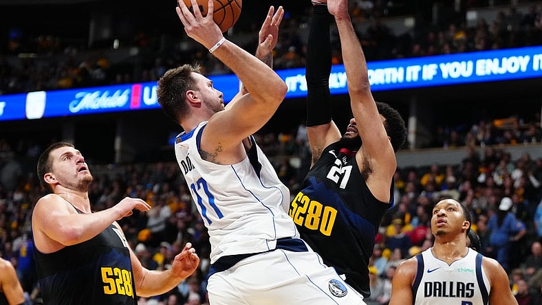Nov 3, 2023; Denver, Colorado, USA; Dallas Mavericks guard Luka Doncic (77) shoots the ball at Denver Nuggets center Nikola Jokic (15) and guard Jamal Murray (27) in the second half at Ball Arena. Mandatory Credit: Ron Chenoy-USA TODAY Sports