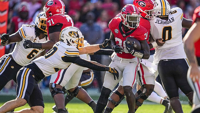 Nov 4, 2023; Athens, Georgia, USA; Georgia Bulldogs running back Daijun Edwards (30) runs against Missouri Tigers linebacker Chuck Hicks (30) during the first half at Sanford Stadium. Mandatory Credit: Dale Zanine-USA TODAY Sports