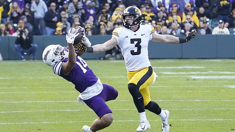 Nov 4, 2023; Chicago, Illinois, USA; Northwestern Wildcats wide receiver Cam Johnson (14) tries to catch a pass as Iowa Hawkeyes defensive back Cooper DeJean (3) defends during the first half at Wrigley Field. Mandatory Credit: David Banks-USA TODAY Sports
