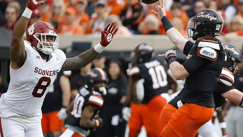 Nov 4, 2023; Stillwater, Oklahoma, USA; Oklahoma State Cowboys quarterback Alan Bowman (7) throws a pass over Oklahoma Sooners defensive lineman Jonah Laulu (8) during a game at Boone Pickens Stadium. Mandatory Credit: Bryan Terry-USA TODAY Sports