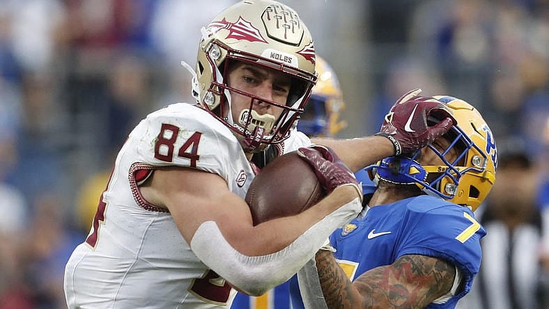 Nov 4, 2023; Pittsburgh, Pennsylvania, USA;  Florida State Seminoles tight end Kyle Morlock (84) stiff arms Pittsburgh Panthers defensive back Javon McIntyre (7) after a catch during the second quarter at Acrisure Stadium. Mandatory Credit: Charles LeClaire-USA TODAY Sports