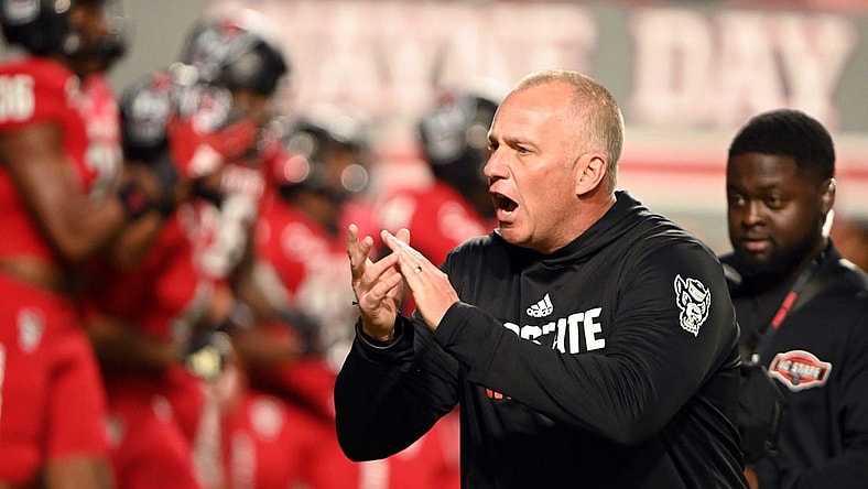 Nov 4, 2023; Raleigh, North Carolina, USA;  North Carolina State Wolfpack head coach Dave Doeren encourages his team as they warm up prior to a game against the Miami Hurricanes at Carter-Finley Stadium. Mandatory Credit: Rob Kinnan-USA TODAY Sports