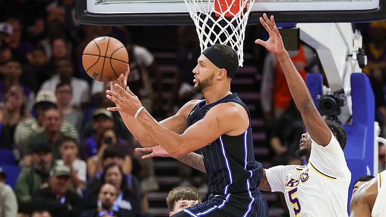 Nov 4, 2023; Orlando, Florida, USA; Orlando Magic guard Jalen Suggs (4) passes the ball in front of Los Angeles Lakers forward Cam Reddish (5) during the first quarter at Amway Center. Mandatory Credit: Mike Watters-USA TODAY Sports
