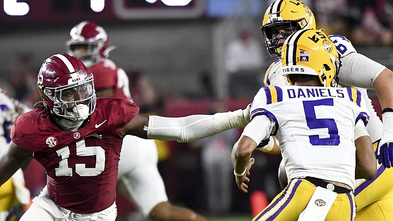 Nov 4, 2023; Tuscaloosa, Alabama, USA;  LSU Tigers quarterback Jayden Daniels (5) escapes the pass rush of Alabama Crimson Tide linebacker Dallas Turner (15) at Bryant-Denny Stadium. Alabama defeated LSU 42-28. Mandatory Credit: Gary Cosby Jr.-USA TODAY Sports