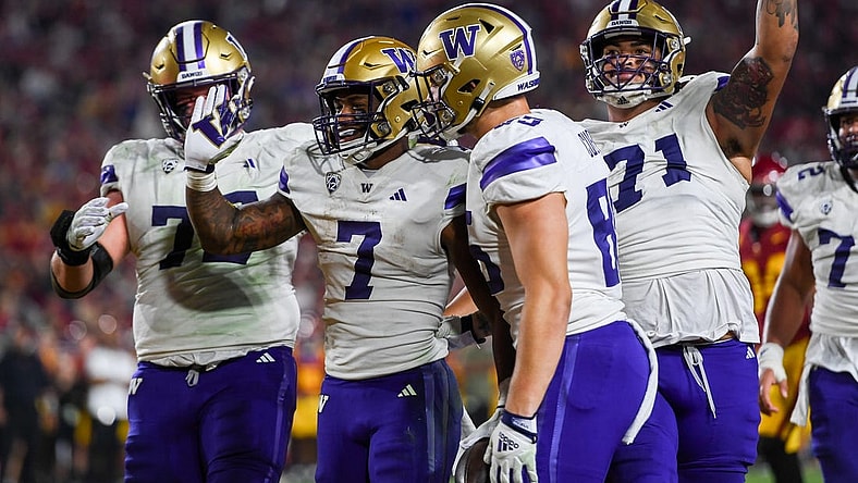 Nov 4, 2023; Los Angeles, California, USA; Washington Huskies running back Dillon Johnson (7), Washington Huskies offensive lineman Nate Kalepo (71) and other teammates celebrate against the USC Trojans during the second quarter at United Airlines Field at Los Angeles Memorial Coliseum. Mandatory Credit: Jonathan Hui-USA TODAY Sports