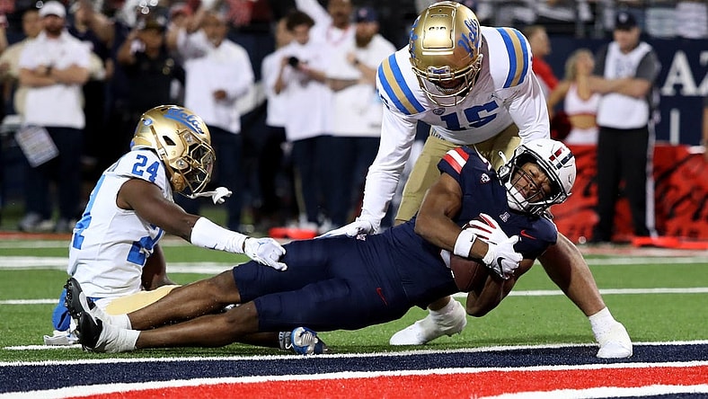 Nov 4, 2023; Tucson, Arizona, USA; Arizona Wildcats wide receiver Montana Lemonious-Craig #5 dives into the endzone against UCLA Bruins defensive back Jaylin Davies #24 and defensive lineman Laiatu Latu #15  during the first half at Arizona Stadium. Mandatory Credit: Zachary BonDurant-USA TODAY Sports