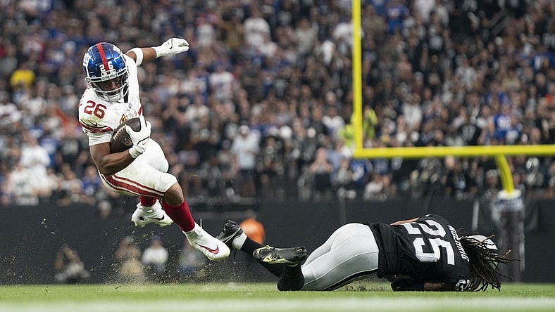 New York Giants running back Saquon Barkley (26) is tackled by Las Vegas Raiders safety Tre'von Moehrig (25) during the third quarter at Allegiant Stadium. Mandatory Credit: Kyle Terada-USA TODAY Sports
