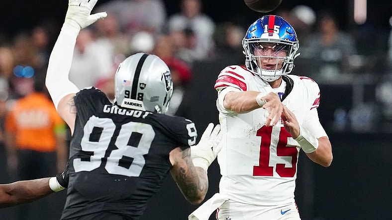 Nov 5, 2023; Paradise, Nevada, USA; New York Giants quarterback Tommy DeVito (15) is pressured by Las Vegas Raiders defensive end Maxx Crosby (98) during the fourth quarter at Allegiant Stadium. Mandatory Credit: Stephen R. Sylvanie-USA TODAY Sports