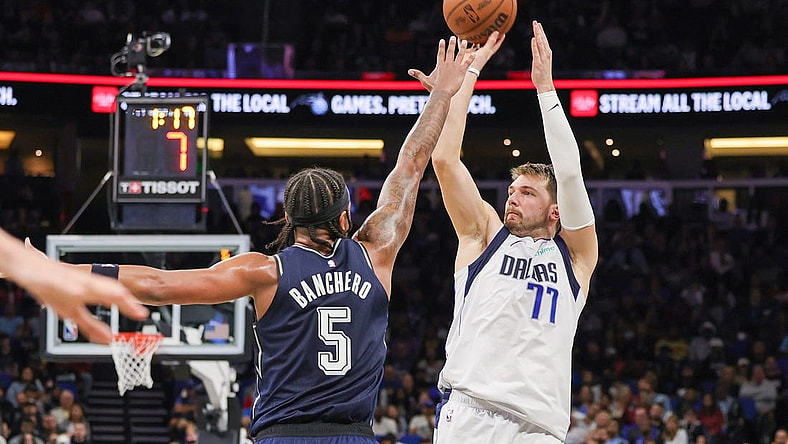 Nov 6, 2023; Orlando, Florida, USA; Dallas Mavericks guard Luka Doncic (77) shoots the ball against Orlando Magic forward Paolo Banchero (5) during the second quarter at Amway Center. Mandatory Credit: Mike Watters-USA TODAY Sports