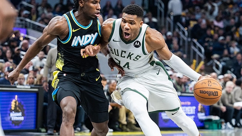 Nov 9, 2023; Indianapolis, Indiana, USA; Milwaukee Bucks forward Giannis Antetokounmpo (34) dribbles the ball while Indiana Pacers forward Aaron Nesmith (23) defends in the first quarter at Gainbridge Fieldhouse. Mandatory Credit: Trevor Ruszkowski-USA TODAY Sports