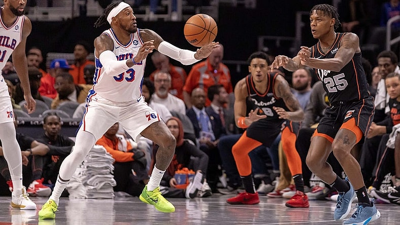 Nov 10, 2023; Detroit, Michigan, USA; Detroit Pistons guard Marcus Sasser (25) passes the ball past Philadelphia 76ers forward Robert Covington (33) during the in the first half at Little Caesars Arena. Mandatory Credit: David Reginek-USA TODAY Sports