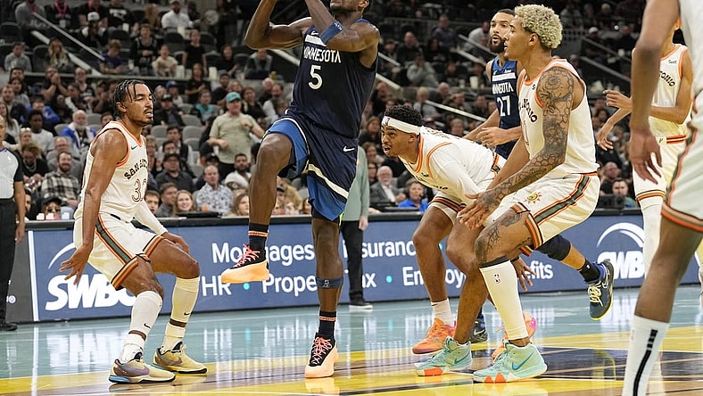 Nov 10, 2023; San Antonio, Texas, USA; Minnesota Timberwolves guard Anthony Edwards (5) drives to the basket between San Antonio Spurs forward Jeremy Sochan (10) and guard Tre Jones (33) during the second half at Frost Bank Center. Mandatory Credit: Scott Wachter-USA TODAY Sports