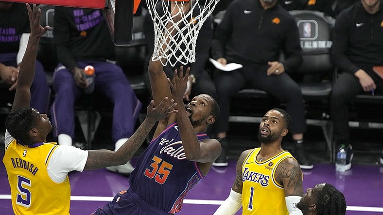 Nov 10, 2023; Phoenix, Arizona, USA; Phoenix Suns forward Kevin Durant (35) scores between Los Angeles Lakers forward Cam Reddish (5) and guard D'Angelo Russell (1) in the first half at Footprint Center. Mandatory Credit: Rick Scuteri-USA TODAY Sports