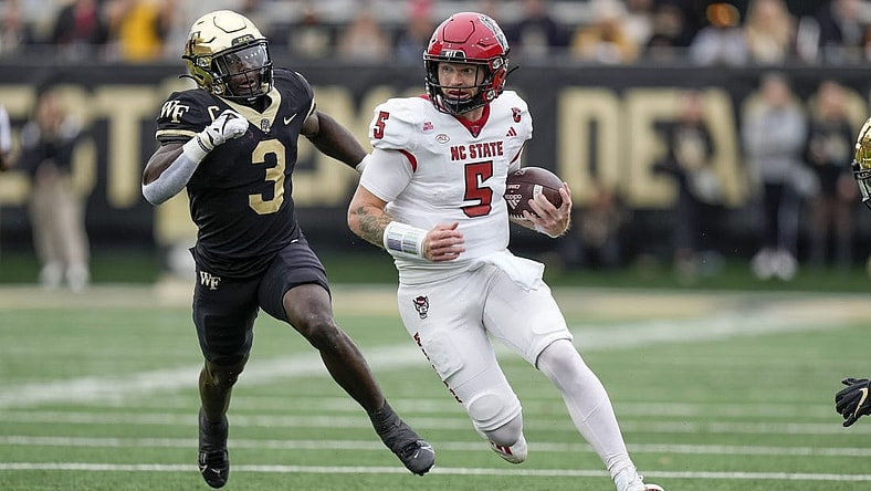 Nov 11, 2023; Winston-Salem, North Carolina, USA;  North Carolina State Wolfpack quarterback Brennan Armstrong (5) tries to outrun Wake Forest Demon Deacons defensive back Malik Mustapha (3) during the first half at Allegacy Federal Credit Union Stadium. Mandatory Credit: Jim Dedmon-USA TODAY Sports