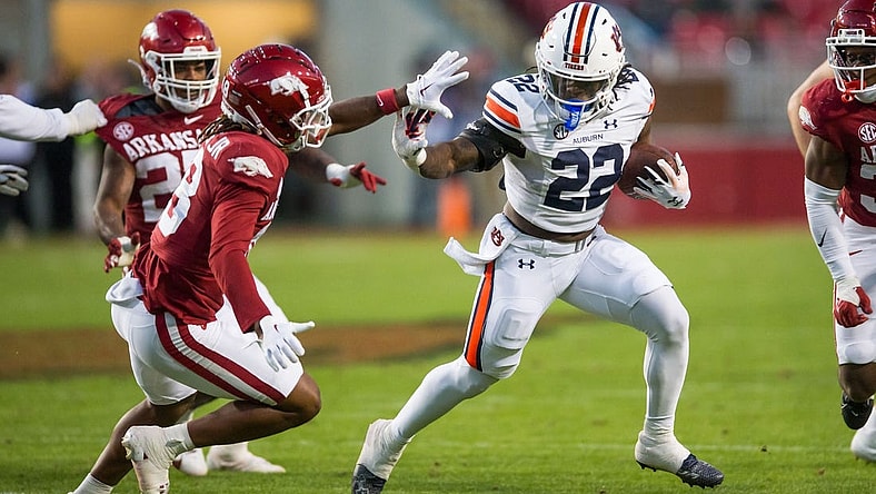 Nov 11, 2023; Fayetteville, Arkansas, USA;  Auburn Tigers running back Damari Alston (22) tries to fight off Arkansas Razorbacks defensive back TJ Metcalf (18) during the third quarter at Donald W. Reynolds Razorback Stadium. Auburn won 48-10. Mandatory Credit: Brett Rojo-USA TODAY Sports