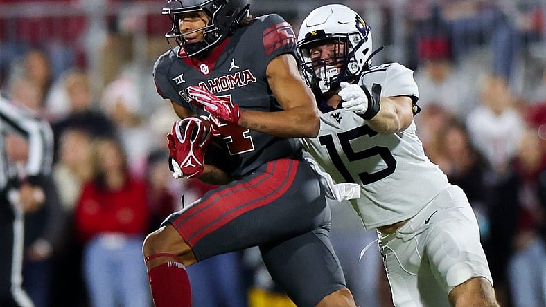 Nov 11, 2023; Norman, Oklahoma, USA;  Oklahoma Sooners wide receiver Nic Anderson (4) runs with the ball as West Virginia Mountaineers linebacker Ben Cutter (15) defends during the first quarter at Gaylord Family-Oklahoma Memorial Stadium. Mandatory Credit: Kevin Jairaj-USA TODAY Sports