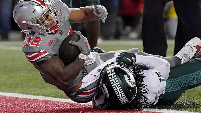 Nov. 11, 2023; Columbus, Oh., USA; 
Ohio State Buckeyes running back TreVeyon Henderson (32) dives into the endzone (32) while he is tackled by Michigan State Spartans defensive back Angelo Grose (15) to score a touchdown during the first half of Saturday's NCAA Division I football game at Ohio Stadium.
