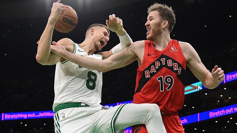 Nov 11, 2023; Boston, Massachusetts, USA;  Toronto Raptors center Jakob Poeltl (19) fouls Boston Celtics center Kristaps Porzingis (8) during the second half at TD Garden. Mandatory Credit: Bob DeChiara-USA TODAY Sports