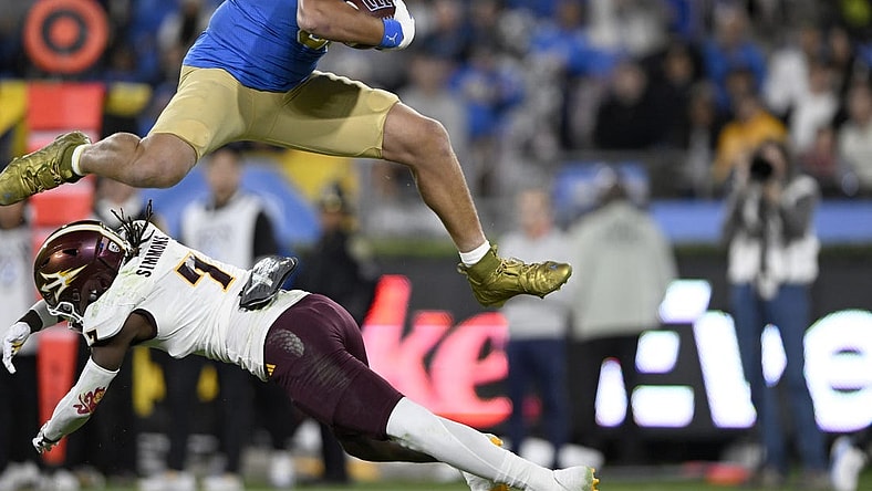 Nov 11, 2023; Pasadena, California, USA;  UCLA Bruins tight end Moliki Matavao (88) leaps over Arizona State Sun Devils defensive back Shamari Simmons (7) after making a catch during the first half at the Rose Bowl. Mandatory Credit: Alex Gallardo-USA TODAY Sports