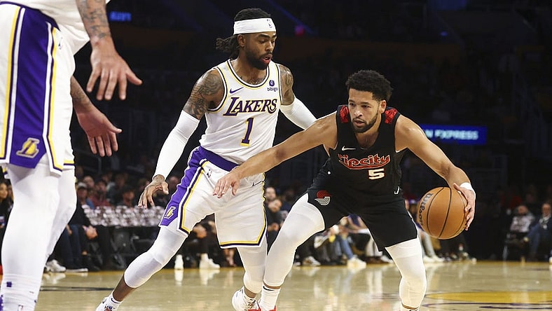 Nov 12, 2023; Los Angeles, California, USA; Portland Trail Blazers guard Skylar Mays (5) drives against the Los Angeles Lakers guard D'Angelo Russell (1) during the first half of a game at Crypto.com Arena. Mandatory Credit: Jessica Alcheh-USA TODAY Sports