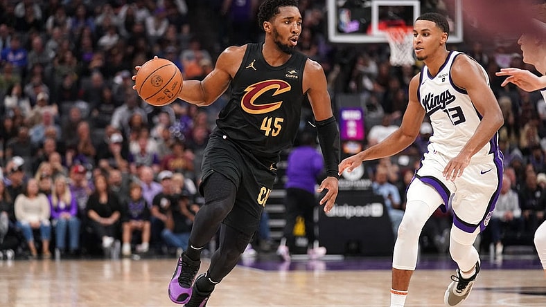 Nov 13, 2023; Sacramento, California, USA; Cleveland Cavaliers guard Donovan Mitchell (45) dribbles the ball next to Sacramento Kings forward Keegan Murray (13) in the second quarter at the Golden 1 Center. Mandatory Credit: Cary Edmondson-USA TODAY Sports