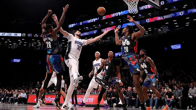 Nov 14, 2023; Brooklyn, New York, USA; Orlando Magic center Goga Bitadze (35) fights for a rebound against Brooklyn Nets forward Dorian Finney-Smith (28) and center Day'Ron Sharpe (20) during the second quarter at Barclays Center. Mandatory Credit: Brad Penner-USA TODAY Sports